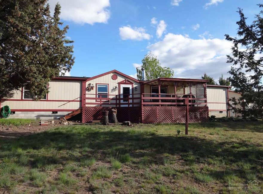 Move to the peaceful neighborhood of High Desert Estates. The home and property have been well-cared for and maintained. The house features include a living room with a double-sided wood burning fireplace, a formal dining room and a family room with a pellet stove. The master suite has a soaking tub and step-in shower and is on the opposite end of the house from the other bedrooms. The spacious 2 acre lot offers tons of space to park RVs and toys, and has a detached garage with a workout room, a greenhouse, a small storage shed and a larger storage shed that could be used as a small shop. The property has views of Mt. Jefferson and Grizzly Mountain, and is conveniently located within 15 minutes of shopping, dining and schools.