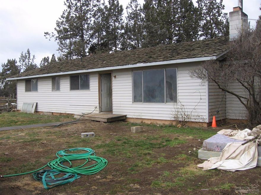 Nearly 29 acres with 22.5 acres irrigated. Very close in with good access to Hwy 97 north & south. 4BD, 2BA single level home needs major TLC. Lots of trees, pump house, several small outbuildings, ponds, flood irrigated, borders the suburbs, but very private, 2 door detached garage with shop area. Property has excellent long term upside/development potential. Great site to build your future dream home.