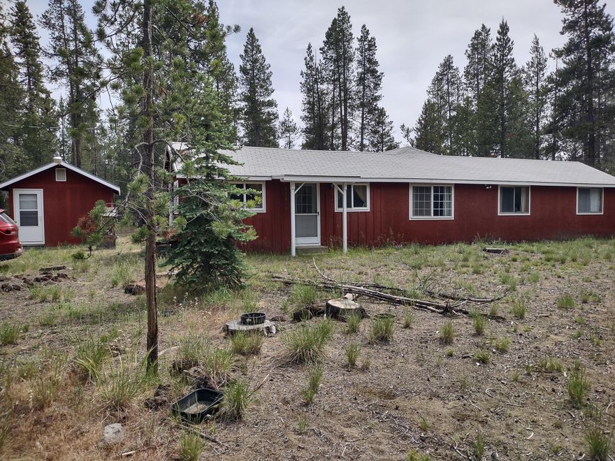 Cozy-private home on an acre+ in La Pine, lovingly updated over the years but ready for your finishing touches - a hidden gem with so much potential. Featuring 2 bedrooms, potential for 2 baths, good well, newer windows, and a spacious living area. Functional kitchen with room to enhance. Available furnished from TVs to silverware to beds, plus many materials to finish it are on site and included. Pump house offers full laundry, secondary refrigerator, storage, & a shower, creating a secondary living space or convenient addition. Acre lot directly West also available. Make this well-loved getaway your own!