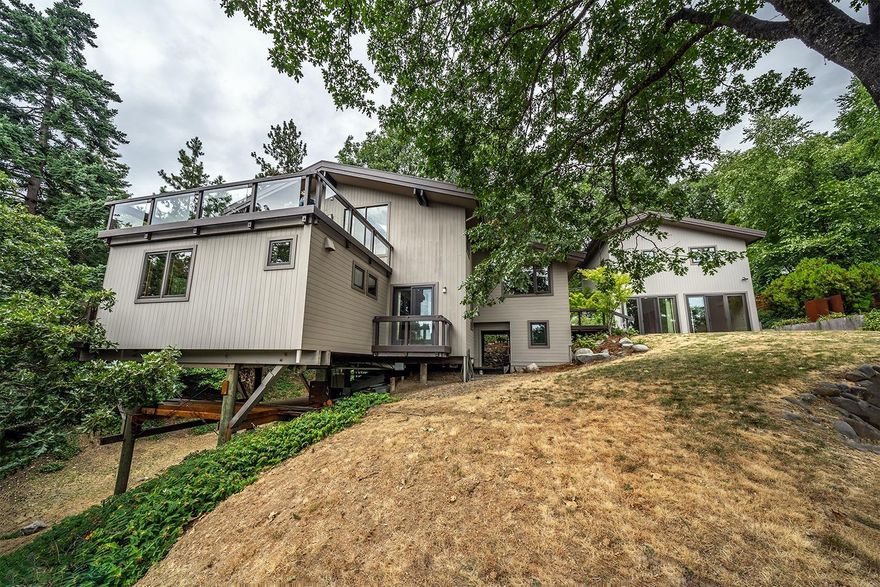 Unique architectural details, modern design, and award-winning accessory unit located within three blocks of Ashland's Lithia Park. Features of the Pole House designed and built by architect Jeff Barnes in 1980 include a true open concept floor plan with exposed wood columns and beams, vaulted ceilings, oak flooring, and large skylight/windows with retractable shades. The kitchen is equipped with a low profile five-burner induction range with downdraft exhaust fan, convection oven, leathered granite counters, oak slab eating bar, under-cabinet lighting, tiled backsplash, and extensive oak cabinetry. The remodeled master bath has a black quartz counter, vessel sink, and a seamless glass and tile shower with dual heads. The accessory dwelling unit designed by architect Richard Wagner features a bedroom, office, full bathroom, and was recognized by the City of Ashland in 2012 with an award for Historically Compatible New Accessory Structure.