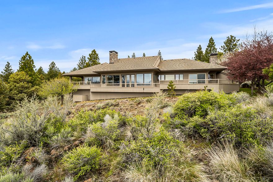 Spectacular panoramic views from this custom single level home in NW Bend's Hillside Park. Carefully constructed by Rick Francis with timeless design by Steven VanSant. Open great room floor plan complete with extensive vaulted ceilings, massive basalt wood burning fireplace, custom built-ins and plenty of windows to welcome the natural light and gorgeous views of the Old Mill District, Lava Butte and the Paulinas. Large island kitchen with stainless steel appliances extends to a cozy family room with wood accents, fireplace and both an informal and formal dining areas. Spacious primary suite with walk in closet and private bath with jetted tub, double vanity, and sauna. Don't overlook the designated office and junior suite with designated bathroom. Outstanding outdoor living at with extensive decking is perfect for entertaining. Situated on over 1 acre near the top of Awbrey Butte with an inviting paver driveway/courtyard, tile roof, plus much more. This is a truly special home.
