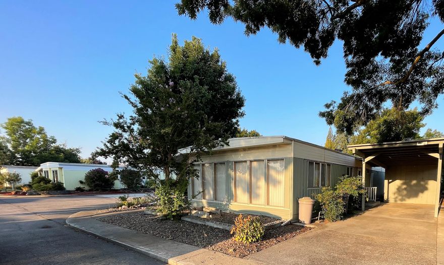 Two bedroom, two bathroom 1968 Leisure Manor mobile home on a corner lot in the Aspens on the Creek community. Exceptionally large windows throughout bring lots of natural light. Convenient accessibility features. Spacious primary bedroom with lots of closet space and an attached primary bath. Large kitchen with plenty of storage, dining room, and a separate living room. Attached covered patio with an accessible ramp, and an attached carport with a large secure storage room. The Landscaping and flowerbeds are just awaiting your green thumb.