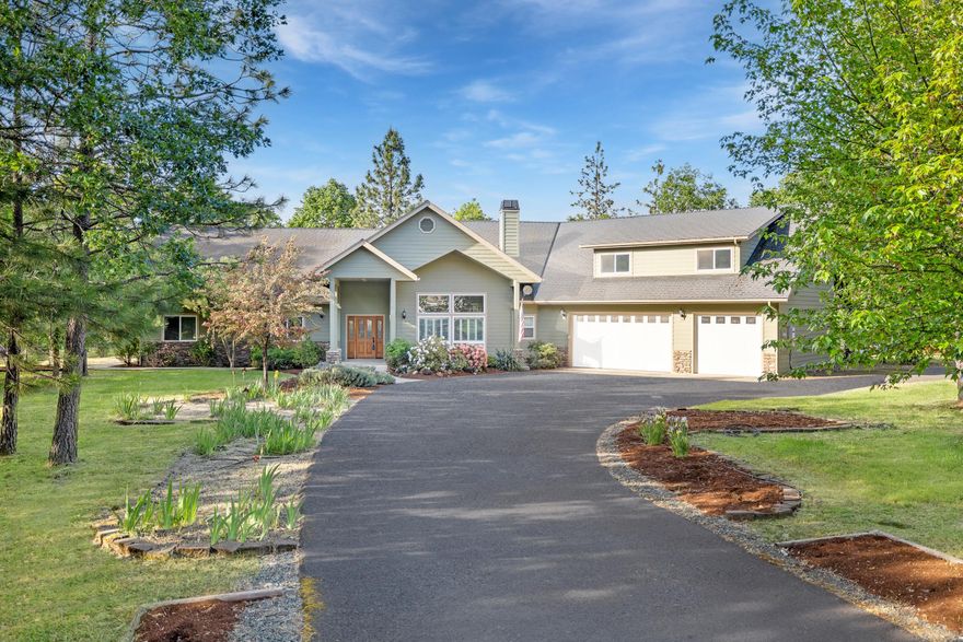 Custom Northwest Craftsman on 2.5 level acres just minutes from Grants Pass! Built in 2006, this spacious 3,470 sq ft home offers 4 bedrooms, 3 baths, and 10-foot ceilings throughout. A vaulted great room features floor-to-ceiling windows, hardwood floors, and a slate-hearth wood stove. Granite-island kitchen includes gas cooktop, double ovens, pantry, breakfast nook, and tile floors. Main-level primary suite boasts a jetted tub, walk-in tile shower, and dual vanity. Two additional bedrooms, an office/sewing room, plus a versatile 650+ SqFt upstairs 4th bedroom/flex room. Enjoy the enclosed sun porch, greenhouse, shaded patio, and fenced gardens. Attached oversized 3-car garage plus detached 40x30 shop/RV garage with roll-up door offer ample parking and workspace. Paved circle driveway, private 18 GPM well, propane generator, heat-pump HVAC with central air,  RR-2.5 zoning, and no HOA. Move-in ready—all appliances included!