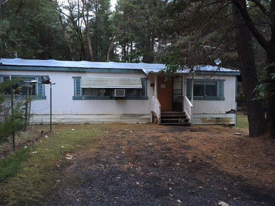 Nice mix of deciduous and native conifers on 2.51 acres Merlin area. Land is level to rolling. 1990 manufactured home that protects home site with County. Area of good wells. Double car garage and two storage buildings. Remove existing dwelling and build or replace with new manufactured home. Good candidate for a Land/Home package with a builder or see a local manufactured home dealer. Manufactured home on the property, not livable, and please do not attempt to enter the home. It is not considered safe, or the porches/decks surrounding it. Sold AS IS, the home is there to protect the home site. Will not finance. Cash offers only.