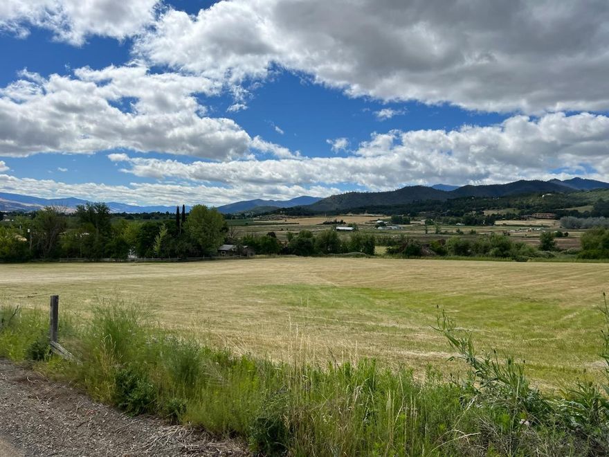 Another huge price reduction!!!  9.97 acres in one of the most desirable areas in the Valley.  Surrounded by horse stables, vineyards and pear orchards this stunning piece of property with beautiful views is just minutes from downtown, but feels very rural.  The 1928 sq. ft  manufactured home is well kept and would be perfect to live in while you build your dream home.  Above the attached 2 car garage is an added bonus, a 600 sq. ft. room (not included in sq. ft.) with 3 bay windows and a 1/2 bath.  Perfect for the kids game room or the man/woman cave.   The old barn is down and so there's alot of old barn wood.  There is also a little outbuilding in need of repair.  There are 9+ irrigated acres so plenty of water for your crops or animals. With some thinning out of the overgrown landscaping and some major tidying up, this could easily be a stunner.  Short term owner carry available.