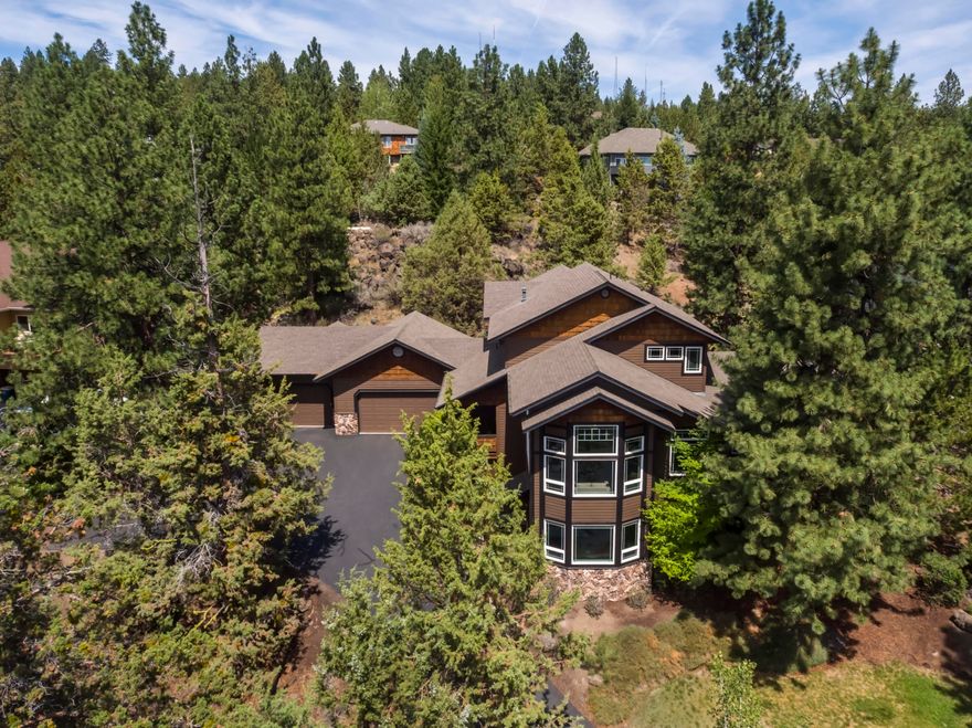 Located on the southern flank of Awbrey Butte, this inviting home is nestled in the trees yet designed to highlight the views and lights of the city and mountains to the south. Light and bright, the open floor plan flows from the entry to the living spaces and central kitchen. High ceilings and many windows bring the outside in. The family room featuring a beautiful stacked stone fireplace, opens to a protected front deck and rear outside living area. The spacious primary suite on the main level has a fireplace & access to the patio & hot tub. Upstairs there are 2 bedrooms & bathroom, plus a bonus room/office/4th bedroom. On the lower level the spacious office, with separate exterior entry, could also serve as guest room. Easy access to the huge unfinished basement. Attached 3 car garage, over 1000 sq ft, also offers lots of storage. Private and peaceful, the ½ acre retreat includes natural elements, a cascading water feature, lawn front and back, and frequent visits from wildlife!