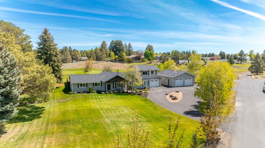 At the eastern edge of town, a little slice of paradise waits for you on nearly two acres, with plenty of room for your shoulders to drop & your smile to grow. Remodeled & expanded, this immaculate home welcomes you into an open main living space where large windows bring in the sunshine. A well-appointed kitchen speaks to your inner chef with a center island handcrafted from reclaimed barn wood & custom metal work. Set apart in its own wing, the primary suite includes vaulted ceilings & a luxurious bath with separate vanities, soaking tub, heated floor & walk-in tile shower. A 2nd primary suite with heated bathroom floors, additional bedroom, full bathroom & office with wood accent wall complete the main level. Upstairs, a large bonus room provides added flexibility. Outdoor living is easy here where a sheltered courtyard includes a paver patio & hot tub & a large pond is surrounded by an expansive lawn. The 1 car attached & 2 car detached garages complete this one-of-a-kind package