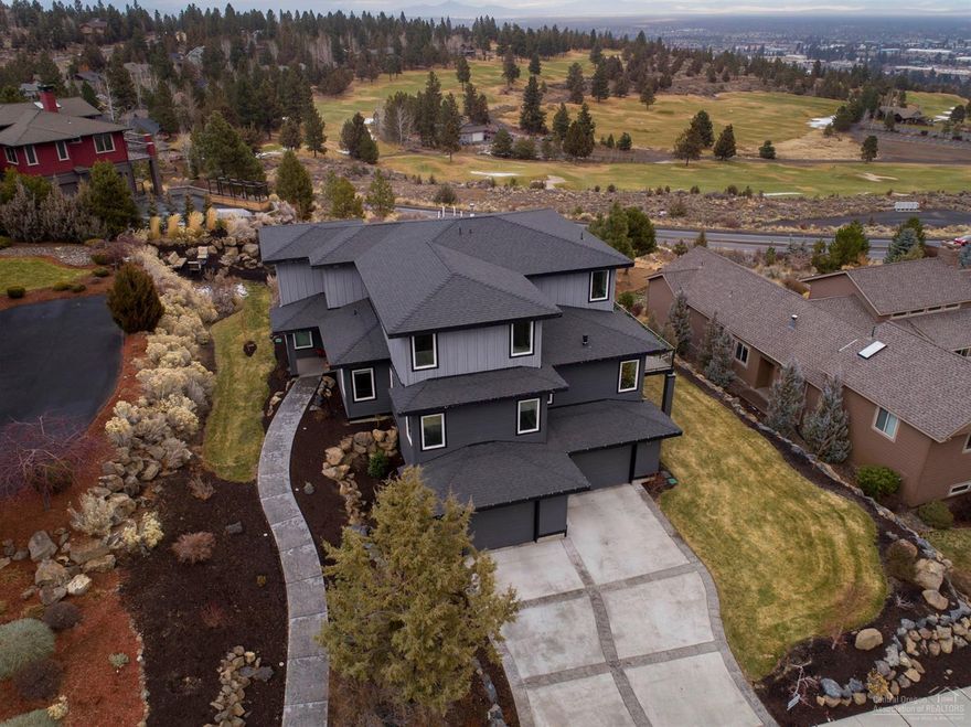 Modern industrial prairie style home w/stunning views of the golf course, city & beyond. Watch the sunrise over the Ochocos & the twinkling lights of Bend every evening. Grand entry leads to Gourmet Kitchen w/bar seating for a small crowd. Open to Living area w/cozy gas fireplace accented w/hammered steel. Recycled brick wall serves as a unique backdrop! Main level Master Suite, spacious Bath w/huge walk in shower & oversized closet. Additional bedroom/office on main floor. Upstairs you'll find 2 guest rooms, deluxe bathroom & a bonus room w/an amazing view from every angle. Sleek staircase wraps around a 3 story tall one of a kind lighting showpiece. 1924 sf Garage w/built in storage, custom floor, dumb waiter & even a wine cellar! Outdoor entertaining areas expand from the wrap around deck to fire pit area that looks over the golf course. Don't miss!