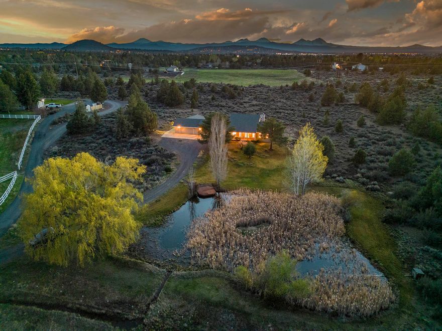 A rare opportunity to own just under 10 acres, minutes from Bend! Enjoy the Cascade Mountain views, abundant wildlife & the beautiful sunrise overlooking the 6.5acre irrigated field & pond. This home offers plenty of space and is ready for you to make it your own. The primary bedroom is
on the main floor and offers separation & privacy. Mountain views from the living room, kitchen and breakfast nook area. Nice dining area off of the kitchen and a large utility room w/ plenty of cabinetry. The two bedrooms upstairs also provide quite the view! Great loft area upstairs w/ plenty of
storage. Heat pump provides A/C & there's a wood stove to enjoy through the winter. Double attached garage with storage & work area. Includes an additional attached large shop/garage/office with extra parking. Newer roof & exterior paint. Makes for a great horse/livestock property. Reach out today for a tour!