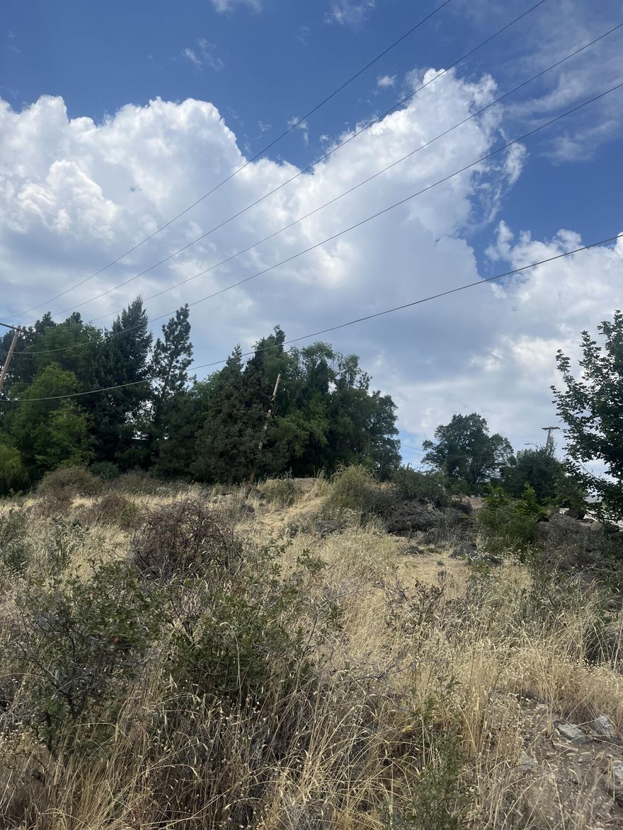 Perched above Klamath Fall's western stretch of Main St., this vacant piece of land presents a unique canvas for a developer or a dream-seeking homeowner. Set upon a slope, the lot's elevated perspective grants a front-row seat to the flow of life on the road below, Highway 97. Feel free to drive by the lot. Please be courteous of the neighbors. Buyer to complete due diligence