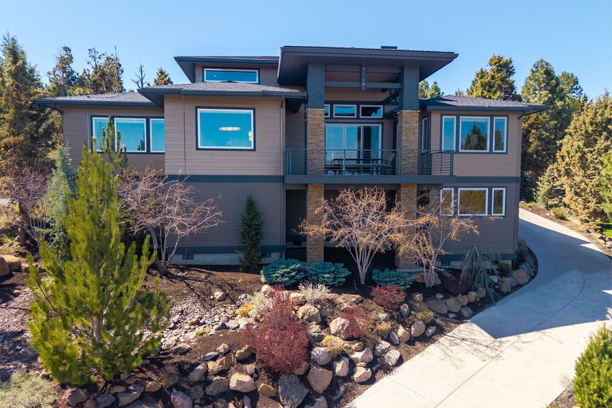This Northwest contemporary stunner offers sweeping Easterly views that stretch from Mt. Jefferson to the Ochoco Mountains. Perched high in Bend's distinguished Awbrey Park, the heated driveway leads effortlessly to the grand entrance. Vaulted ceilings & expansive windows invite light & landscape into the single level floor plan, with just the bonus room with half bath on the lower level. The kitchen features a generous quartz island, separate stainless fridge & freezer, double ovens, bar with dual wine fridges & walk-in pantry. The dining area & deck are positioned for the morning sun & shaded evenings. The primary suite features views & deck access, a sitting area and luxury bath with a steam shower, double vanities, & large walk-in closet. A second en suite bedroom also features views and luxury bath. 2 additional guest rooms share a main floor full bath. Solar panels provide energy savings and sustainability. Don't miss the park, playground & river trail access just steps away!
