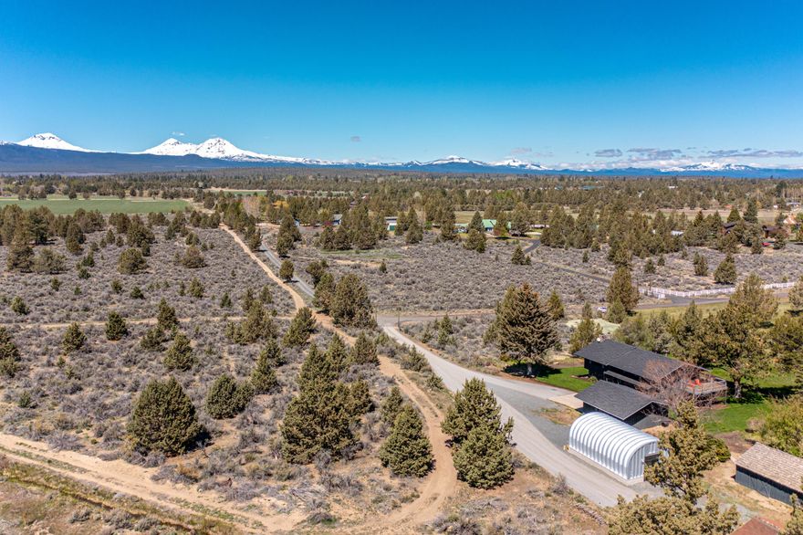 Stunning Cascade Mountain views & park like setting, this property is the quintessential Tumalo dream! This 9 acre parcel is comprised of two lots of legal record adding considerable value, extra build-able lot for generational living/future development! Fully updated 3bd 3ba home w/ thoughtful & modern finishes throughout. Huge mountain views from every living space, enjoy the pristine open concept kitchen featuring custom white oak cabinetry, & quartz waterfall counters. Generous primary suite w/ sliding doors to ¾ wrap around deck perfect for enjoying the privacy & natural beauty of the property. Fully permitted 600 sqft auxiliary building offers elegant usable space for home office or convert to ADU. 9 acres w/ 4.5 acres Tumalo Irrigation water rights, huge pond for unmatched wildlife sighting & a well-maintained pasture makes this property perfect for equestrian use. Quiet end of the road privacy just minutes from town, this is the Tumalo oasis property you've been waiting for!