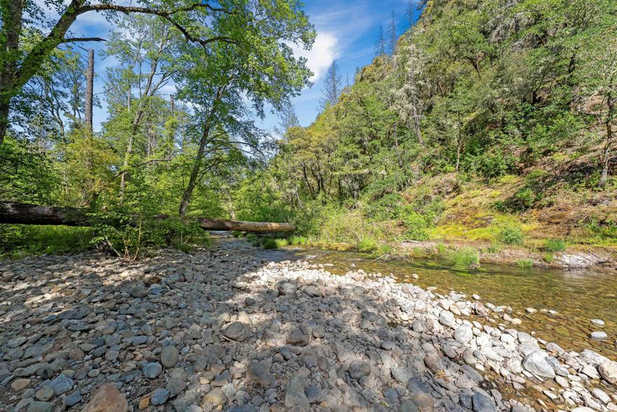 Here is your unique opportunity to own 4.24 acres along the beautiful Slate Creek. The land features a mix of trees and open space, great creek frontage with a shared well already in place-making it even more ready for your vision.  Whether you're seeking a peaceful retreat, or an investment opportunity, this scenic property offers a lot, and you don't want to miss out. There is a neighboring property located at 9367 Redwood Hwy for sale for $215,000, this property has a manufactured home on it and a well/septic.