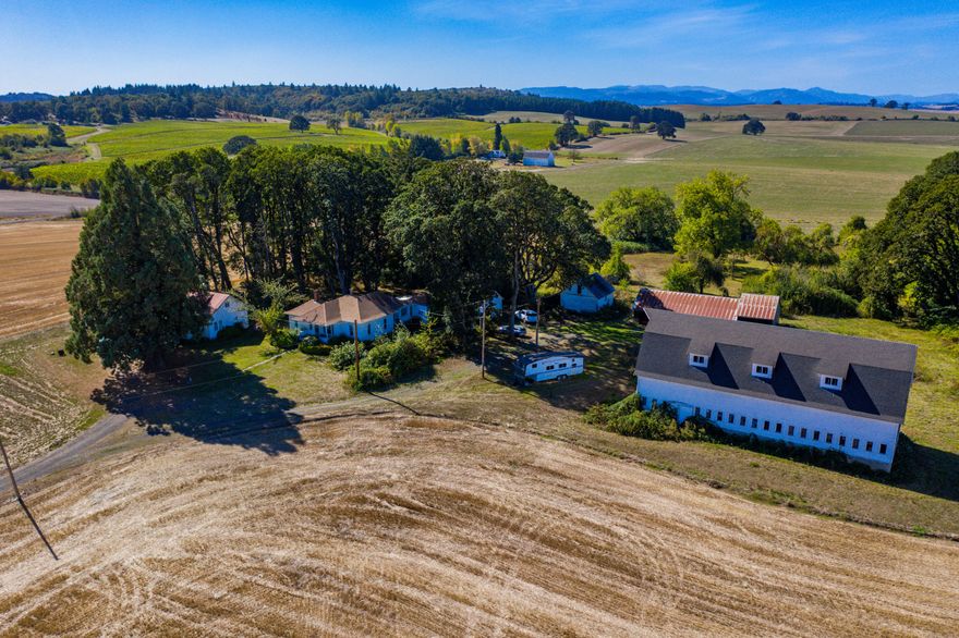 This farm features two legal dwellings situated at the top of a long private driveway, providing sweeping views of the Eola Hills and the endless farms below. The charming Dutch colonial barn is in excellent condition and could be repurposed for a wedding venue, party palace and/or a basketball court. Whether you choose to remodel the existing homes or build your dream residences, this farm offers an excellent opportunity in a prime location.This property offers a rare chance to acquire two legal residences on a highly productive farm, ideally located near the cities of Salem, Dallas, and Corvallis. Historically, this farm operated as a dairy, before transitioning to the production of grass seed and hay, taking full advantage of the area's good Class II soils and unique climate.