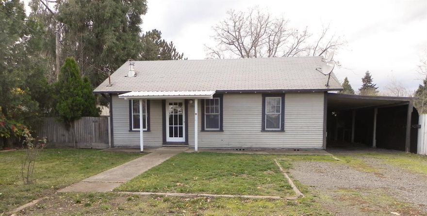 Great for 1st time homebuyer or investor. It has been a long time rental. Seller has cleaned it up and added new vinyl, carpeting, paint and some repairs. He's done. It is ready for the new owner and whatever touches they might want to add. Nice size living room with an accent wall. Kitchen has good working space with dishwasher & refrigerator included. The nice sized dining area adjacent to kitchen has wainscoting. Indoor utility room. The enclosed breezeway used to be a covered patio. It is not included in the square feet. The carport is long enough for two vehicles in tandem. The single car garage has been used as a shop but could house a compact car. There is an additional storage room with dirt floor at the back of the shop. All this on a .25 acre lot. Over the back fence is home to a couple of cows. Country setting but close to town. Griffin Creek school area.