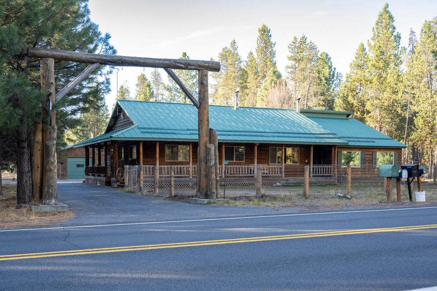 Charming Craftsman on 3.52 Acres with Guest Cottage, Shop & RV Parking!  Surrounded by mature Ponderosa Pines, this 3BD/2BA, 2,103 sq ft home combines rustic beauty with modern comfort. Features include log accents, oak laminate floors, maple cabinetry, tiled counters, and stainless appliances. Enjoy a new 2025 HVAC system, durable metal roof, and wrap-around covered deck perfect for relaxing or entertaining. The fenced front and back yards are ideal for pets and gardening, with multiple fire pits for gatherings. A private guest cottage with full bath and kitchenette offers space for guests or extended family. Property also includes a two-bay shop, covered RV parking with hookups, asphalt parking, paved access, and a wrap-around driveway. Mature trees have been selectively thinned to enhance the natural setting. Peaceful, private, and move-in ready—perfect for modern country living!