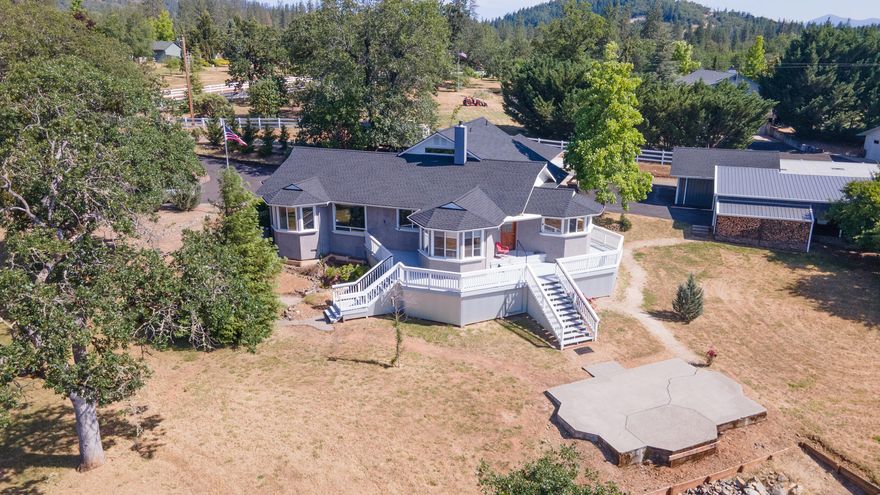 Bay windows enhance the spectacular views from this amazing home with half surround deck to further enjoy the views.   Seller has made substantial improvements since owning this lovely home (see attached list) and a big variety of upgrades.  Home is on one level with an upper level loft that is the perfect craft room with so many nooks, shelves and cabinets for storing your supplies.   Huge primary bedroom with lots of closet space, large bath with soaker tub and enclosed toilet with sink in enclosure.  Lots of storage space in home and extra cabinets added.   From laundry exit to breezeway (covered carport) to two car garage with half bath for washing up. Behind that is potting area and then another garage that could hold two cars or many cycles.   This shop/ garage has ductless heating and air for comfortable fun in garage.   There is also an incredible wood bin attached.   Gated entrance with remote.  In 2020 well flow test was 12 gpm.  $5000 credit for kitchen appliances.