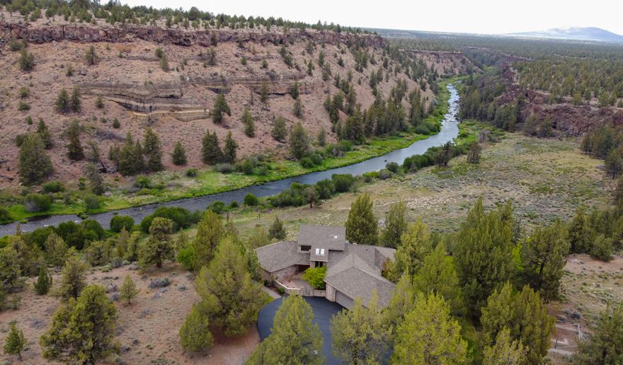 ''Private'' and ''sports enthusiast's paradise'' describe this extremely rare riverfront property of 21 acres w/ private river access. Through a gated community and down a private paved circular driveway, come home to your expansive riverfront property overlooking the Deschutes River carving through the canyon. Enjoy the privacy of no homes across the canyon from you while observing bald eagles soaring thru the sky & deer crossing from one side of the river to the other below you. A private hillside trail provides access to private river frontage with endless fishing & bird watching. A 48 x 48 shop / barn with indoor basketball, putting practice area, weight room & loft w/ space to park your recreational vehicles / toys / boats w/ outdoor covered area for animals. Perfect your golf game with a 120 yard driving range or venture to BLM via a short ATV ride. Home features primary en-suite on main level, hardwood floors, views from all rooms. Seller willing to negotiate renovation credit.
