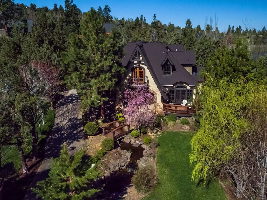 This French Country home offers a beautiful blend of timeless features with a twist of sophisticated European drama. To enter, guests cross over a lovely footbridge with water features on both sides, and into a stone brick grand entryway - to be met with vaulted ceilings, and an open two-story layout. The remodeled kitchen is complete with large granite counter island, timber beams, immaculate reclaimed wood flooring and an absolute perfect space for entertaining. Through the French doors of the dining room you can find yourself on the rear patio with a comfortable stone fireplace and additional primary suite access. Downstairs also includes a very spacious office or additional bedroom. Both upstairs suits are accompanied with an open loft for additional space. Lastly please note the grand 3 car garage with extended driveway complete with additional second story apartment, great separation for guest or mother-n-law suite.