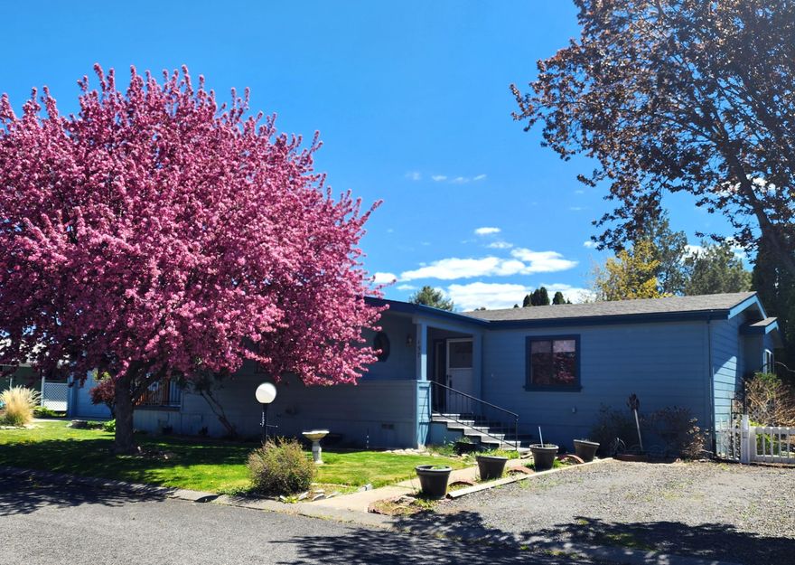 HUGE PRICE DROP! Well-maintained, home in 55+ Suntree Village with single garage! Lg kitchen with Jenn-Air stovetop, newer SS refrigerator, breakfast bar, and huge pantry area. Sliding glass doors in breakfast nook open to front deck with awning. Good separation between bedrooms. Home could be set up for separate living on each side of the home, including a separate entrance. Huge great room plus family room.  Tons of storage throughout. New Roof and laminate flooring in 2020.  All plumbing supply lines replaced. Separate laundry room with sink. Covered area between garage and home. Sm workshop behind garage and private, fenced backyard. Central A/C, extra parking area, home professionally leveled, vaulted ceilings, newer hot water heater, and more! Suntree Village is located across 15th St from renovated Larkspur Sr Center. Space rent is $933/month and includes water, sewer, garbage, debris pick-up, clubhouse, and street snow removal. Sold AS-IS. Come check out this terrific home!