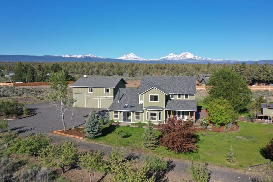 Huge Cascade Mt views on 2.38 fenced acres, between Tumalo and Sisters. This 2950 sq ft, 3 bd/2 ½ ba updated home is nestled at the end of cul-de-sac. Enter through the welcoming front porch into a vaulted entry. Windows throughout the light-filled Great Room frame the majestic Three Sisters. Open kitchen and formal dining room. French doors open to wrap-around deck, a perfect place to enjoy the view. Laundry room and oversized bonus room complete the main level. Wake up to the mountains in the upstairs Primary Suite, with private deck, walk-in closet, and soaking tub. Views from 2 additional bedrooms, and office alcove. Mature fruit trees, water features, play structure, and chicken coop, compliment this large, landscaped yard.  Detached 36'x36' shop has RV pull-through, 3 bays + ½ bath. 864 sq ft apartment above shop has 2 bed/1 bath and vaulted ceilings. Take full advantage of Central Oregon's big, open skies with huge mountain views in the top-rated Sisters School District.