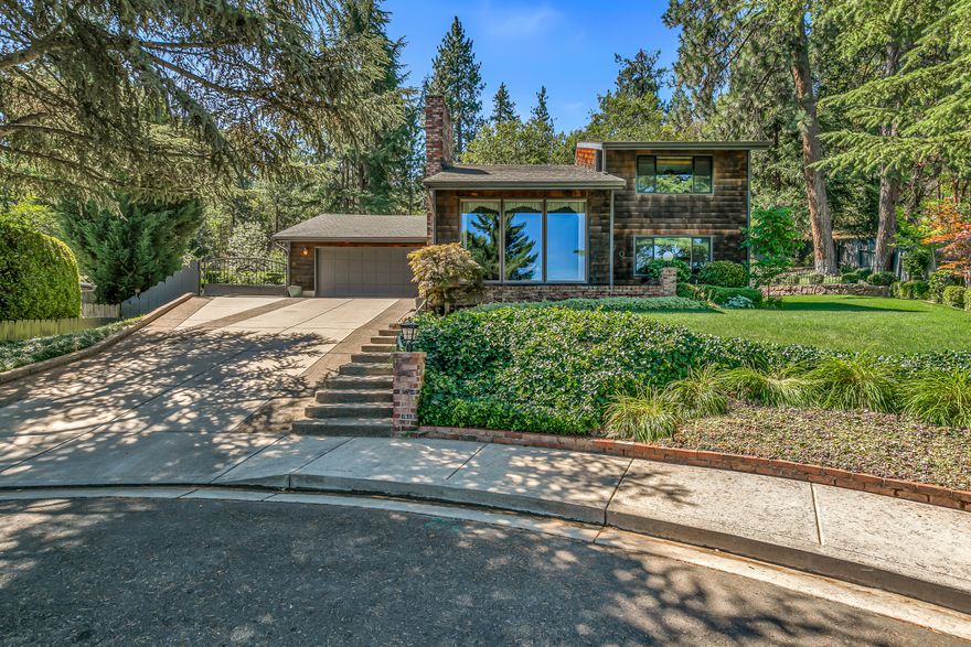 Enter into your own private oasis in one of Southern Oregon's most sought-after towns — Jacksonville. Thoughtfully maintained with exceptional pride of ownership, this 3-bedroom, 2-bathroom home offers 1,648 sq. ft. of inviting living space. Nestled on an elevated lot at the end of a quiet cul-de-sac, large windows frame serene views of a peaceful street just minutes from historic downtown. The beautifully landscaped backyard has been artfully designed by a professional horticulturist, featuring a tranquil water feature, abundant fruit trees, and flourishing garden beds — all blending seamlessly with the sounds of nature. A private gate at the rear of the property offers direct access to the scenic Beekman Arboretum & Trail system. This home offers the perfect blend of privacy, comfort, and charm. Truly a must-tour to appreciate its full beauty.