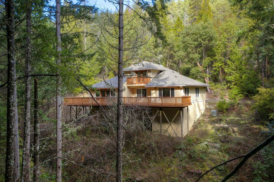 Stunning treed setting plus you can hear the sounds of Mystery Creek, which runs through the property. Great floor plan complete with a living room, 3 bedrooms and 2 baths, plus a large recreation room including a wet bar. Situated on just over 23 private acres with mature evergreens surrounding the home. The master suite has a large walk-in closet and private balcony over looking the creek. Large picture frame windows allow all the natural beauty from outside in. There are french doors leading from the bonus room to the newly refinished deck. Brand new roof, exterior paint were all completed this spring (2016). There is also a large 24 x 36 detached workshop on the property. Most of the land is hillside and treed though there is a small usable area near the workshop. A must see and only a 10 min drive from Talent!