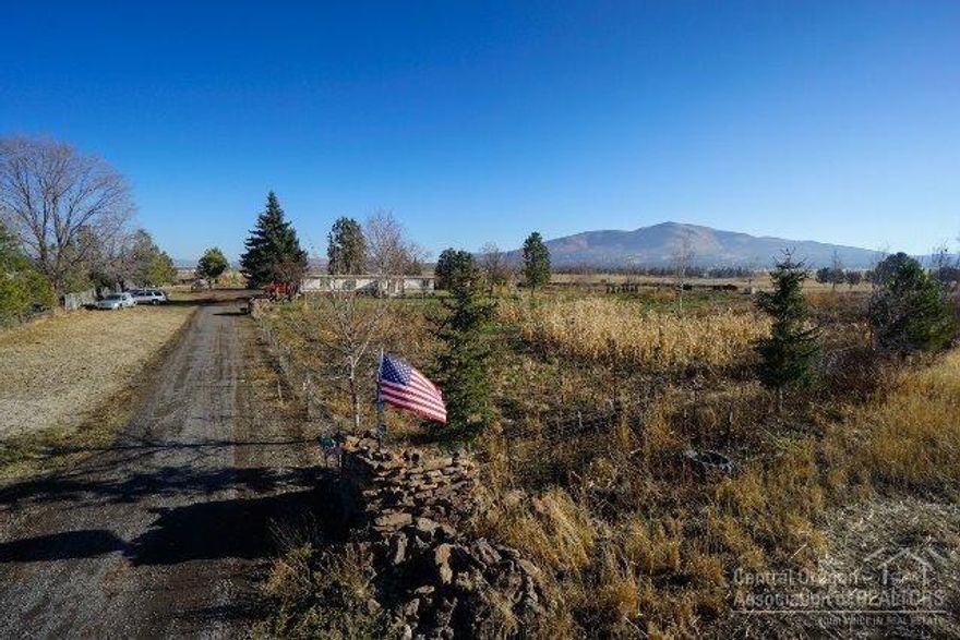 This home site is surrounded on three sides by larger parcels of farmland. Current mfg home was built in July 1976 and is financeable. Has updated windows. Large fenced garden area, fenced pasture area. Nice mature trees. Pond. 2.1 acres of irrigation. 1140sf Hay/Storage building, Shop building. Fantastic Cascade mountain views from the property. Quiet and peaceful setting. Live in the property as is or would make a great building site.