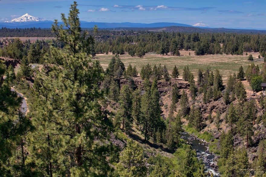 Stunning and rare 1.25 acre setting nestled in above a bend in the Deschutes River that overlooks the river canyon, the new 184 acre Riley Ranch park then on towards the Cascades. Imagine sitting on the deck listening to the tranquil sounds of the river while watching hawks soar above the open land at sunset! Follow these views throughout the home. The home has a triple car garage with a flat driveway plus a detached 2 car garage with fully appointed 724 sqft artist studio above. River trail access too.