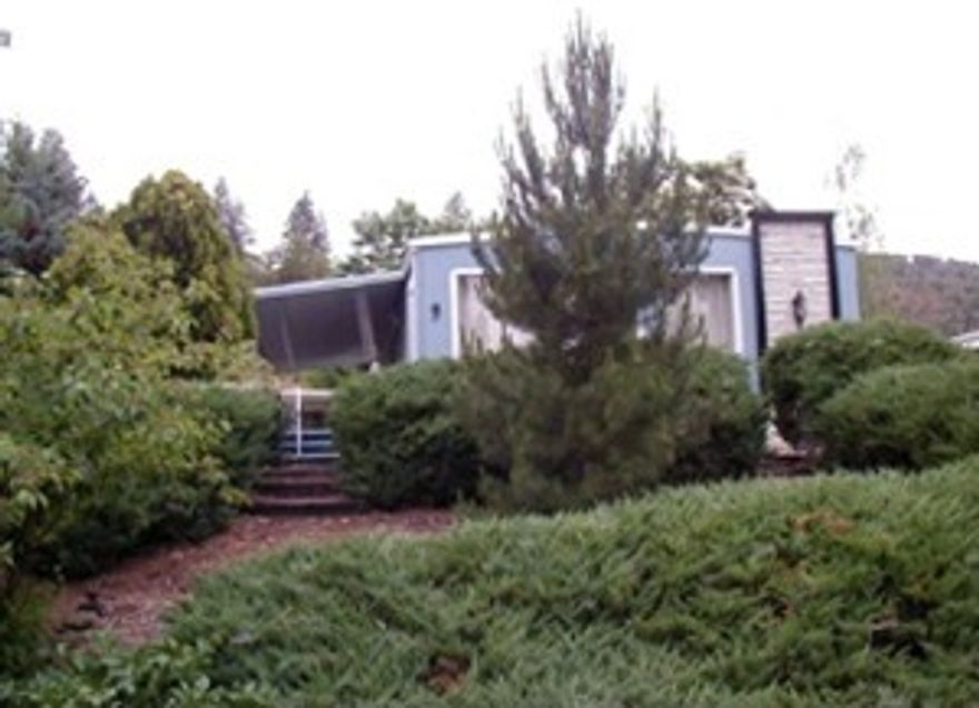 Super location, sits on a hill with great views. Corner lot, lots of trees, 2 driveways, 2 covered carports, workshop, small back yard for garden, backs to open pasture, floor to ceiling windows in living room to enjoy views. Open floor plan, Western carriage Estates, 55+ park.