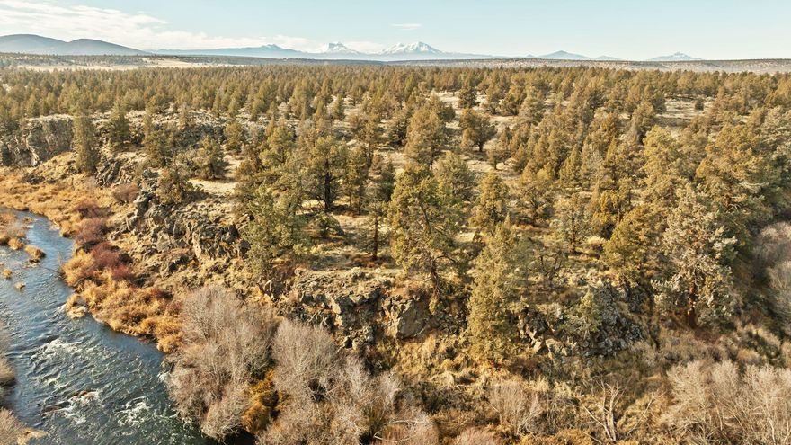 Build your dream home on an exceptionally rare private riverfront acreage with spectacular Deschutes River views and sweeping vistas of the Cascade Mountains. This one-of-a-kind property offers exclusive access to a scenic stretch of the Deschutes River, ideal for nature lovers and outdoor enthusiasts. Natural rock outcroppings and majestic old-growth Juniper trees give the land remarkable character and privacy. Enjoy serene, tranquil living just minutes from Redmond, Bend, and Sisters, combining peaceful seclusion with convenient access to urban amenities. A septic feasibility study is already completed, saving time and cost for your custom home plans. Historic Tetherow Crossing Park is nearby, adding recreational appeal and local charm. Don't miss this rare opportunity for premier riverfront living in Central Oregon!