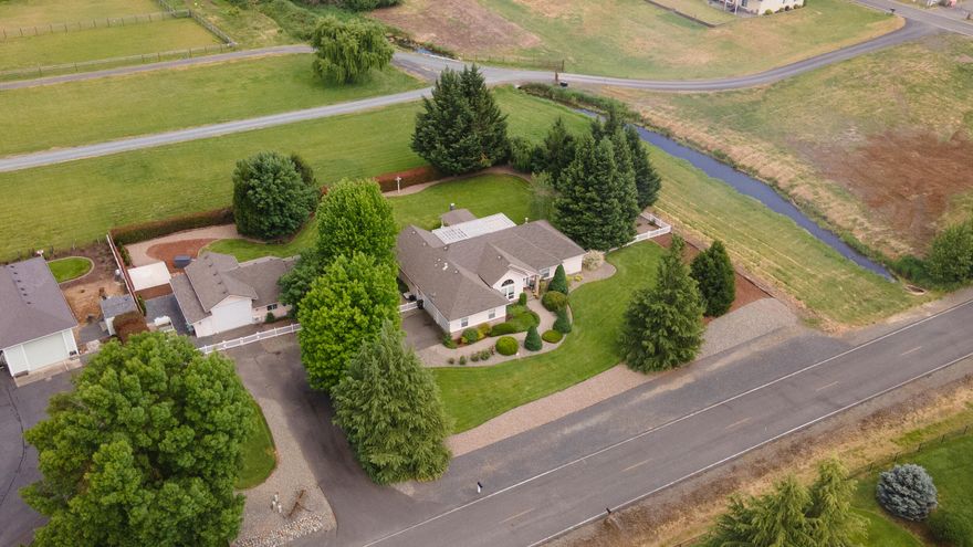 Location! Location! Southern Oregon Dream Property minutes away from the Rogue River and historic downtown Grants Pass. This updated single level home is situated in a peaceful neighborhood on one professionally landscaped acre of land. Features include: split floor plan, maplewood flooring, open floor plan, formal dining, eat in kitchen, and a spacious master suite. Step outside to an additional detached dwelling unit with an RV garage, shop, and locked storage areas that are all ADA accessible. The expansive yard, garden, large covered patio, outdoor covered kitchen with plumbed gas, fireplace, and multiple areas for seating make this home the place for all your family and friends to enjoy! This home has many more amenities. Make an appointment today for your forever home.