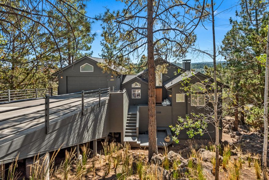 Nestled in the desirable West Hills, this impeccably remodeled home perfectly balances modern sophistication and thoughtful design. Enter into an open-concept great room with high ceilings and expansive windows showcasing stunning views of Mt. Bachelor and the iconic smokestacks of the Old Mill. Relax in the spacious living area featuring a sleek linear fireplace, oak mantle & built-in storage. The main-level primary suite offers a peaceful retreat with a large walk-in closet & custom built-ins. The luxurious en-suite bath includes a deep soaking tub, a spacious shower & dual vanity. Downstairs, find three charming bedrooms, a large bathroom, a versatile bonus room, and 350+ sq ft of bonus room storage. The chef's kitchen is a dream with modern appliances, custom cabinetry & a walk-in pantry. Step onto the newly engineered deck with a hot tub or gather around the terraced fire pit below for outdoor relaxation. Every detail in this home is crafted for comfort, style & functionality.