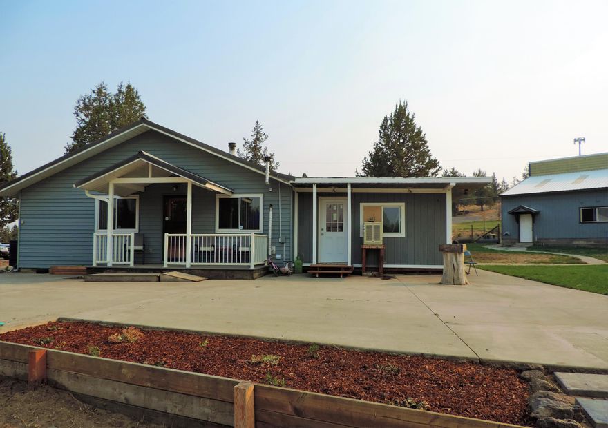 You can't touch anything like this with acreage at this price! Charming 1748 sq. ft. stick built house, permitted addition used as a 3rd bed/bonus room w/attached walk in closet or convert to a bath. House has an open great room concept with a large kitchen and plenty of storage. Natural wood accents on walls for a rustic yet modern look. Newer: Laminate floors, septic system, electrical panel and heat pump. Owners in process of painting and finishing many items.  Large cement patio and huge grass area, partially fenced.  Large 1440 sq. ft. building with RV doors/parking inside, natural light, second floor for additional storage, lots of room to store your tools, toys and everything else.  Bonus! Detached garage has been converted to living/studio/work space.  No water, but lots of potential for addl rental or extended family use. DO NOT just drive by this house! So much potential w/ a little more cosmetic fixing up. Come see this hidden treasure today! Part of Crooked River Ranch