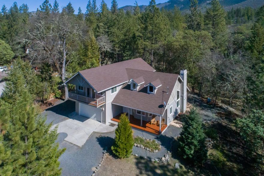 Beautiful 4-bedroom, 3 bath custom home in the Applegate Valley situated on fully fenced half acre.   Bright and spacious with formal living and dining rooms, beautiful hardwood floors, and open floor plan.  The great room has soaring ceilings, a cozy, wood-burning fireplace and French doors leading to the back patio. Master suite, 2 bedrooms and laundry room are all located upstairs.  Each of the upstairs bedrooms have balconies to enjoy the natural setting and mountain views from. Master suite is huge and has walk-in closet, double sinks, and jetted tub. 4th bedroom is downstairs and would make a great home office, guest room or flex room. Beautifully landscaped with seasonal creek, chicken coop and plenty of space for your garden. This home is perfectly situated just minutes from the river, lake, hiking trails and world-class wineries. Only ½ mile to the highly desirable Ruch Outdoor Community School (K-8) and only 10 minutes from Historic Jacksonville.