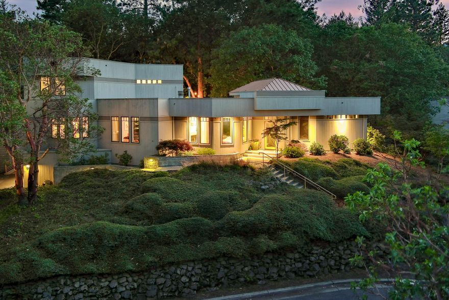 This elegant and modern home offers breathtaking views from above the boulevard yet is just minutes away from downtown Ashland & world-famous Oregon Shakespeare Festival. Rooms are
bathed in natural light through expansive windows highlighting the many high-end finishes and designs. Main level features chefs dream kitchen w/top-of-the-line appliances, wine fridge, living room w/gas fireplace, family room w/wood-burning fireplace & built-in shelving and half bath.
Primary suite is a luxurious retreat w/walk-in closet, built-in cabinetry, dual vanities, jetted tub, toilet room, bidet & walk-in shower. Laundry room is equipped with ample storage plus a dumbwaiter for added convenience. Upstairs are two more bedrooms, fantastic views and a full
bathroom. Outdoor space is a true paradise creating a private, serene & peaceful outdoor environment. XL garage w/separate room for art studio or workshop. This home epitomizes modern luxury living at its finest. Seller is licensed Broker in OR.