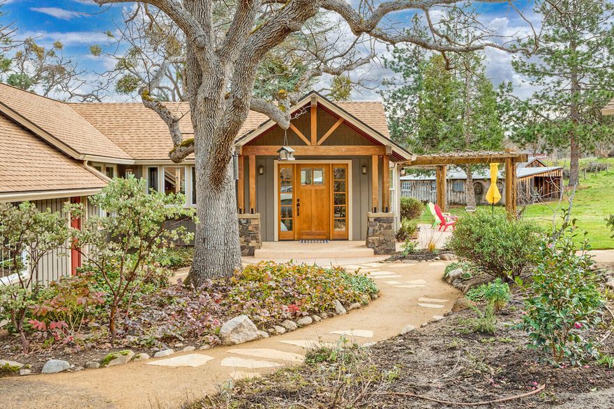 Wonderful, single-level home on over six acres in a highly desired location. With views of the mountains, large pasture, and many recent updates, this home offers so much, yet it is only minutes from Ashland. You will love the open floor plan and ease of living. Hardwood floors tie the living, dining, and kitchen areas together, creating a lovely flow. The open kitchen has custom cabinets and a breakfast bar- perfect for entertaining. The living room has cherry wood built-ins, vaulted ceilings, and a wood-burning stove - a great gathering space. It opens to a deck with a hot tub and mountain views. There are three bedrooms and an office, including a light-filled primary bedroom. Outdoors has garden beds, a sunny, south-facing patio, an apple and pear orchard, 3.7 acres of TID rights, and lots of privacy. Several outbuildings include two barns, a chicken coop, and a canning/potting shed with a solar array. It is a unique property just ten minutes from downtown Ashland.