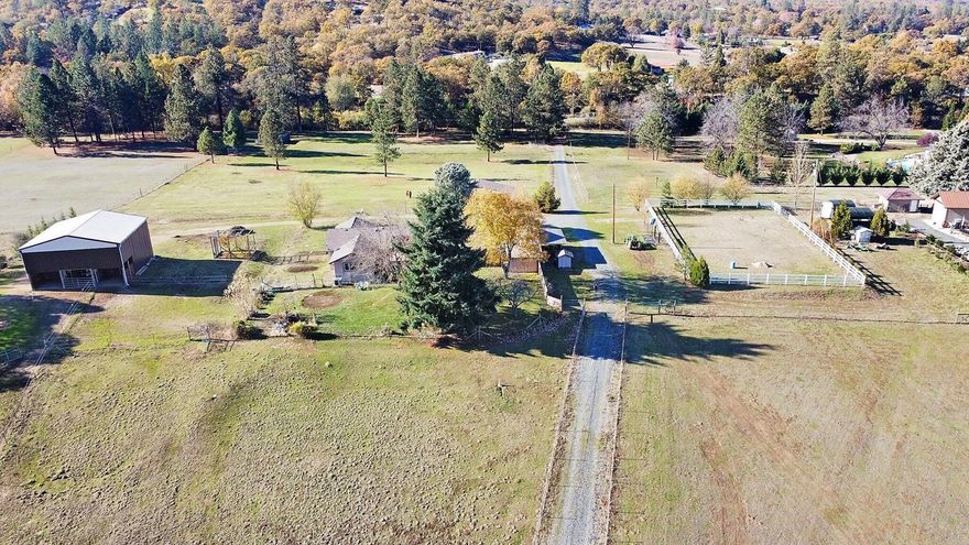 This income producing property is gorgeous w/the long driveway & 360 degree views. Sitting on a small knoll on almost 10 acres, you will find this 1760 sq.ft., 3 bdrm/2 bath home looking over the fenced pastures. This single story home has been well taken care of w/a galley kitchen, garden window, &  eating area. The living room is very large & has a wonderful wood burning stove. There is a wonderful, all season room connecting the home to the garage/shop. Central air and heat. Outside you will find a 36x36 barn that has 3 (possible 4) horse stalls w/two individual paddocks, organic garden, mature fruit trees, koi pond, and another outside barn that has two stalls. There are 5 different fenced off pastures and 70x100 riding arena. The property has 3 wells, tack room, and small shop. There is plenty of room for RVs, equipment, and more.