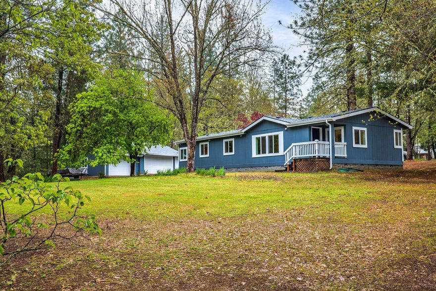 A slice of rural heaven! The home sits upon 1.5 rolling acres of well manicured land for immense enjoyment with minimal maintenance including many flowering trees & a fenced garden area. New Roof & New Paint - 2022. The property is suitable for any maker with a garage/workshop to fill with tools. The circular pull-through driveway provides abundant parking & makes maneuvering trailers a breeze; the large carport is perfect for an RV, boat, quads or other equipment! The home's main living space provides a light, bright, & warm environment including vaulted ceilings, pellet stove heat, & updated laminate flooring.  The kitchen provides ample storage & counter space for the chef of the household, the cabinets are refinished & the counters updated with stone coat epoxy for a modern touch.  Down the hall the master bedroom enjoys a large bath including dual vanity & large soaking tub that takes advantage of natural light. A guest bath, 2nd bedroom, and office/3rd bedroom complete the home.