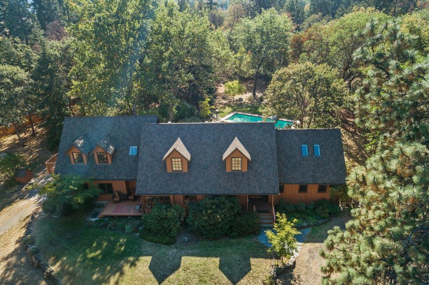 Tranquil country home on 7.52 level, and lightly wooded acres, just 10 minutes from Ashland, Oregon. Situated off quiet Morey Rd the property includes mature oaks, cedar & madrone, TID irrigation rights, and a fabulous in-ground pool. This unique private retreat offers a perfect balance of secluded rural living but conveniently close to town and schools. Additional features include soaring vaulted ceilings, skylights, a Tulikivi masonry heater, oversized garage, detached carport, and a large office with high-speed Spectrum internet. From the board & batten siding and wood framed windows, to the KenCarin designed and Solid Ground installed landscaping, every inch of this property has been well planned and meticulously maintained. Recent improvements include: newer heat pump, 30-year roof, patio area with hot tub, 2000 gallon in-ground concrete holding tank, and a remodeled kitchen and baths. Home inspection, well, and septic info available upon request. Book an appointment today!