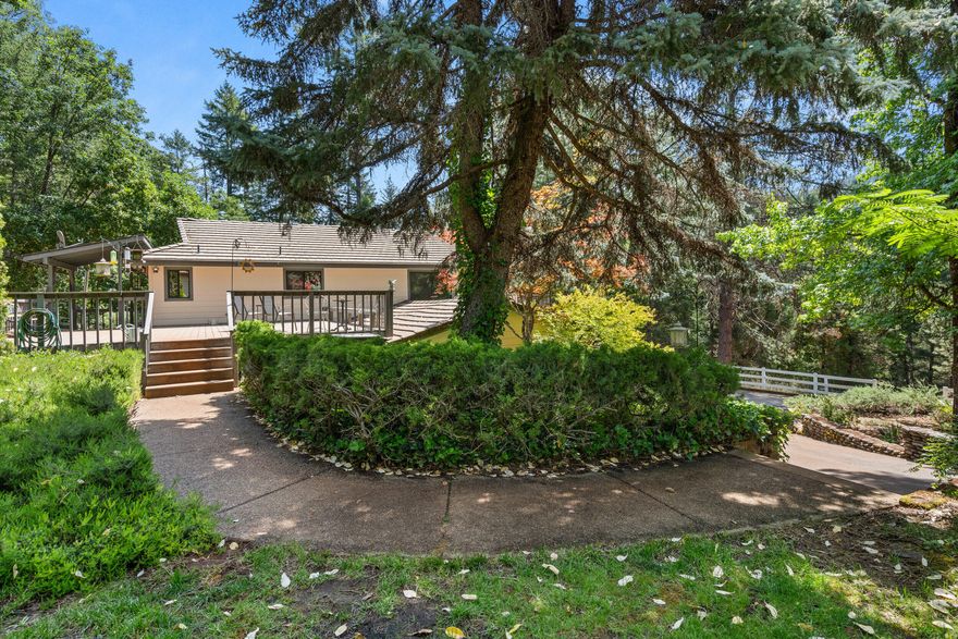 Here's your opportunity to own a breathtaking piece of paradise located on the outskirts of Grants Pass. As you come through the gated entrance and into the woodlands and mature landscaping, and pasture, you immediately  feel at home. Step into this wonderfully bright home to find vaulted ceilings, spacious living areas, a cozy pellet stove and nearly floor to ceiling windows to take in the amazing views. The wide galley-style kitchen has an incredible amount of storage and a beautiful view as well. Downstairs ,is a separate living area with a large adjoining bonus area, currently occupied by a pool table which will be yours as well. Outside you will find a sizable deck that wraps around half of the house, Incredible amount of room for all of your toys. There is a workshop in the detached shop at the garage and huge 3 bay shop with 2 additional smaller bays on each end, all are enclosed. Fenced and cross-fenced pasture, serene koi pond, and lush greenery and more. Welcome home.