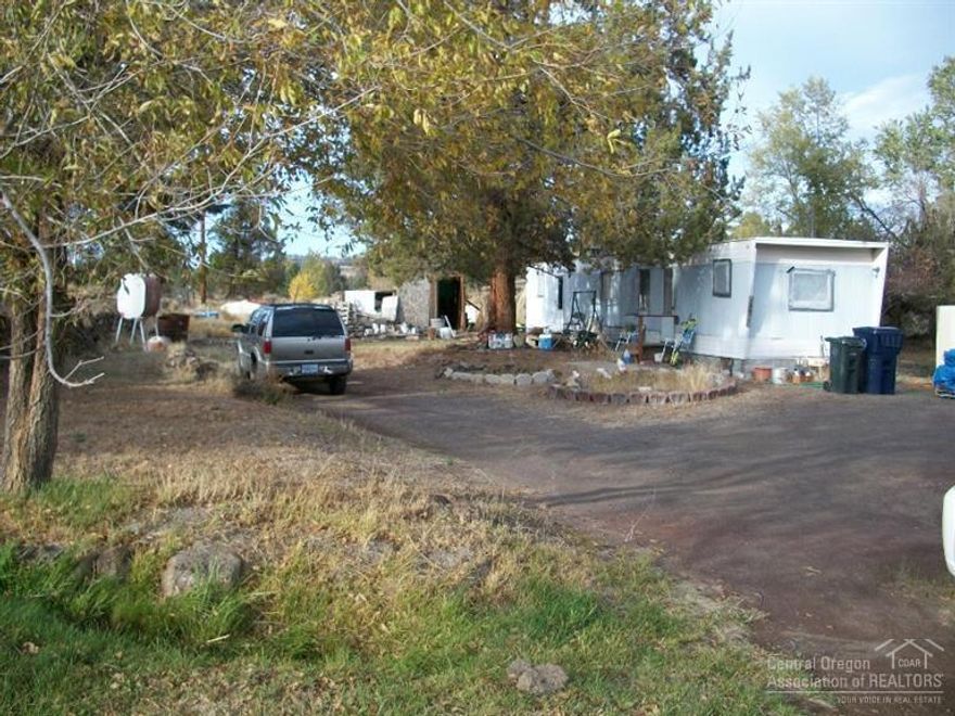Great location between Bend and Redmond! Almost 1 acre with 1/2 acre irrigation & pond. Older manufactured home on the property as-is condition. Perfect for your animals. Great place for your dream house.