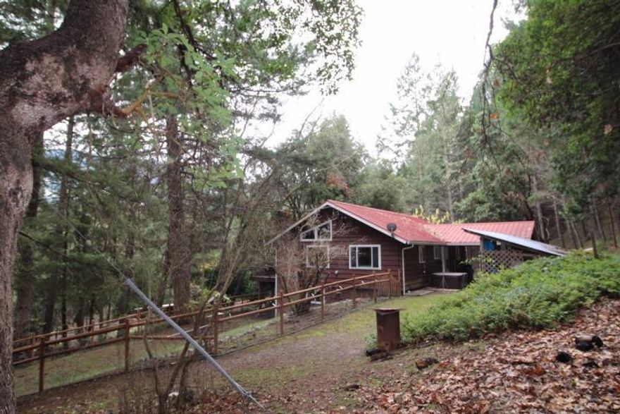 Country Cottage in the Heart of the Applegate! This 12 acre mini farm has it all. A great charming country cottage feel home with an open floor plan and daylight basement. 2 bedrooms and 2 baths with the 2nd bath off of the garage on the lower level along with an office and lots of extra storage. A fantastic tree house feel from the front deck takes in the mountain views. The land is mostly forested with some open fenced pasture area, loafing shed and a chicken palace (coop). There are water right documents that may indicate water rights to this property along with an easement that may allow access to creek for irrigation and recreation. Buyer to verify irrigation rights and easement.