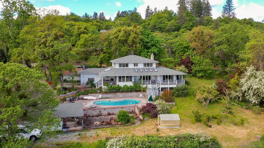 Old Stage Road Country Estate.  This beautiful home was completely rebuilt in 2008 and sits on 12.09 acres, with 8+/- acres in vineyard. Home features hickory floors, granite counters, nice functional kitchen with pantry; morning room with views to the mountains, living room with gas fireplace; formal dining room; large main floor master suite with Brazilian Cherry wood floors, gas fireplace, walk-in closet, walk-shower and sauna;   Upstairs another master suite/office and 2 additional bedrooms.  Outside features 5 stall barn, tack room, hay storage and riding dressage arena and 1100 sq ft shop, and a few other out buildings.  There is also an inground Salt Water Pool with solar heating.  New paved driveway.  Nice mature landscaping includes variety of fruit trees. The property is zoned EFU and has MID irrigation.  This property has magnificent views of the mountains and has many possibilities.