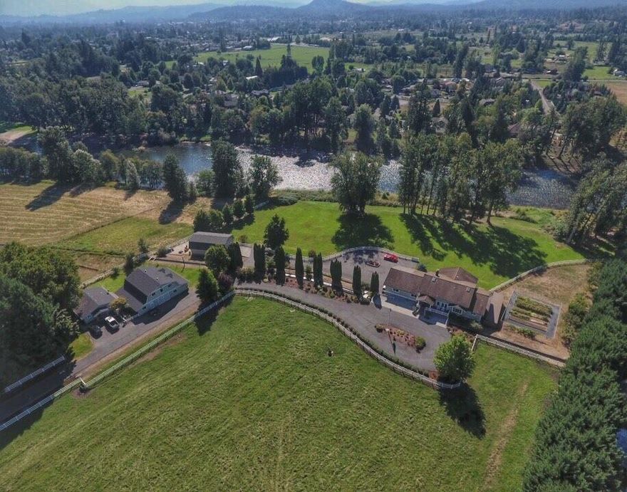 Fabulous river front beauty on 8.01 ac with gently sloping lawn to the banks of the World famous Rogue River. 5206 sf on the main level is perfect for entertaining, featuring a wall of windows for river views and spacious back deck. Open floor plan has high ceilings, gourmet kitchen, wet bar, formal dining room and stone to ceiling fireplace. Large master w/French doors to a covered river front deck, 2 bedrooms, 2 baths and laundry room complete the 1st level. Lower level has 2 bdrms & lg family rm area. Property includes a detached 990 sf guest home with 2 bd, 1 ba. Outside has a 2 story barn w/3 stalls & 1/2 bath and detached shop to house 4 cars. Newer roof on barn and shop. A paved driveway leads to 2 circular driveways & gorgeous manicured grounds. Property sits behind gated entrance and vinyl fencing to secure 5 acres of pasture ideal for vegetation, horses or livestock. The grounds & gardens are kept luscious from a good flowing well. Rural country setting just minutes to town.