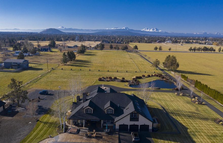 This gorgeous 9.06-acre property is located just minutes from downtown Bend! With stunning views of the Cascade mountain range, the stately entryway leads past a beautiful pond and water feature to a circular driveway. The 4,946 square foot home features timely elegance, with a formal living and dining space, a luxurious master bedroom and bathroom, and bonus office space with spectacular westerly views on the main floor. The open kitchen features a large island and breakfast nook, adjacent family room, and bright and airy sunroom with plenty of natural light, overlooking the spacious patio and in-ground pool. With 8.2 acres of COID water rights, this exquisite property is a must-see!