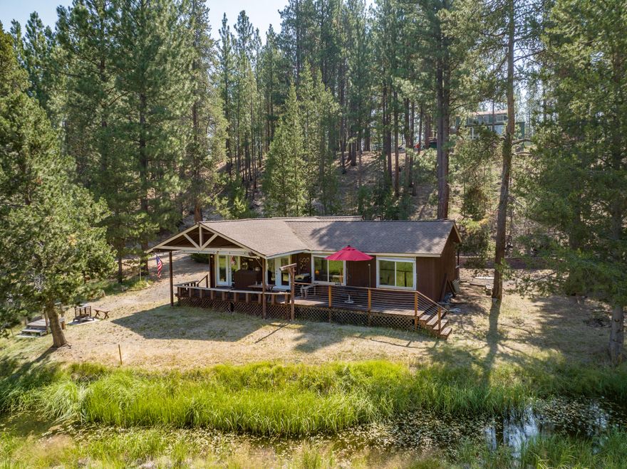 Turnkey, Quintessential cabin located next to the Big Deschutes River with it's own private inlet to take you to the river!  Original Log cabin was added on in 1989 and remodeled by current owner 4 - 5 years ago.  2 beds, 1 1/2 bath, hardwood and slate flooring throughout.  French doors off of each bedroom.  Views of the river from the living room, kitchen and front bedroom.  Kitchen is graced with granite counter tops, hickory cabinets, soft close drawers, lazy Suzan, trash compactor and gas stove.  Nice sized panty!  Bathroom has one vanity and slate shower. Electric fireplace in living room and KoolKing air stand alone air conditioner. Newly stained decks with built in benches.  Single car garage is plumbed for washer and dryer. Bunkhouse and Outhouse!!  New 250 gal Propane tank.