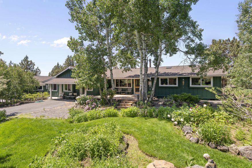 A hobby farmer's dream in Bend's coveted Conestoga Hills! This one-of-a-kind single level 4-bed, 3-bath home on 2.15 gated, fenced, and cross-fenced acres offers luxury living with rural charm. Inside, high-end craftsmanship shines with custom wood ceilings and floors, detailed molding, built-ins in every room, and a stunning rock fireplace with handmade ironwork. The chef's kitchen features stainless steel counters, butcherblock, and premium appliances. Indulge in a marble bathroom with heated floors. A private guest suite with its own entrance and full bath adds flexibility. Outdoors, the property is an oasis: lush landscaping with rock pathways, a tranquil pond water feature, and a firepit gathering space. Hobby farmers will appreciate the two high-end chicken coops, the oversized detached garage, multiple outbuildings for workshops and storage, and a beautiful custom wood-framed greenhouse ready for year-round growing. Refined, functional, and truly one-of-a-kind. A must see!