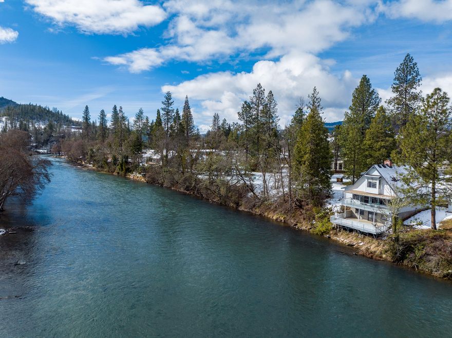 Take advantage of this rare opportunity to live or vacation on the Rogue River; it doesn't get much closer to the water than this one. Relaxing on the lower deck will have you set directly above the mighty Rogue River as it flows by this quaint town. This charming home includes 3 levels, all with magnificent views of the river. The living room has expansive windows, a lava rock fireplace and the kitchen features upgraded granite counters and newer cabinets with loads of storage space. The lower level walkout basement offers additional space, and has most recently been used as a woodshop; it features sliding glass doors to a deck right above the river. This river setting with lawn or garden space has been a legacy property for generations, and it is time for the next owner to make their mark. A detached space offers lots of potential as well, it could make a great workshop or possibly a guest space or second home (buyer to do due diligence on possible uses).