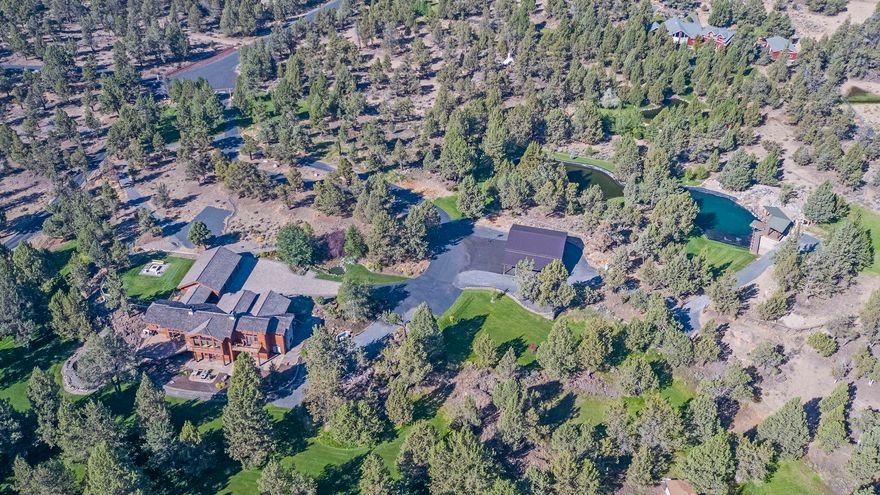 Northwest Luxury Lodge living just 15 minutes from Bend.  From the moment you enter the long-paved drive the attention to detail is evident.  This property boasts almost 10 manicured acres with trails, 800,000 gallon pond and swimming area with custom waterfalls, pavilion and decking, multiple waterfalls throughout the property, fenced dog park with firepit, 1300 sf RV garage, 480 car port, room for everything, the home has 5 full suites, floor to ceiling rock fireplace and massive windows to enjoy the land, chefs kitchen with two islands, media room with full kitchen, downstairs family room, office and ability to create two living spaces.  RV hookups, 3 car garage and more.